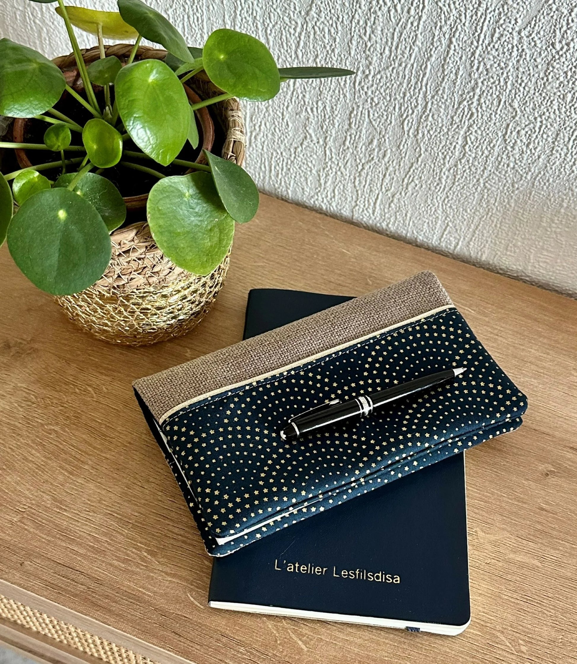 Mise en scène du porte chéquier beige et bleu à étoiles dorées.