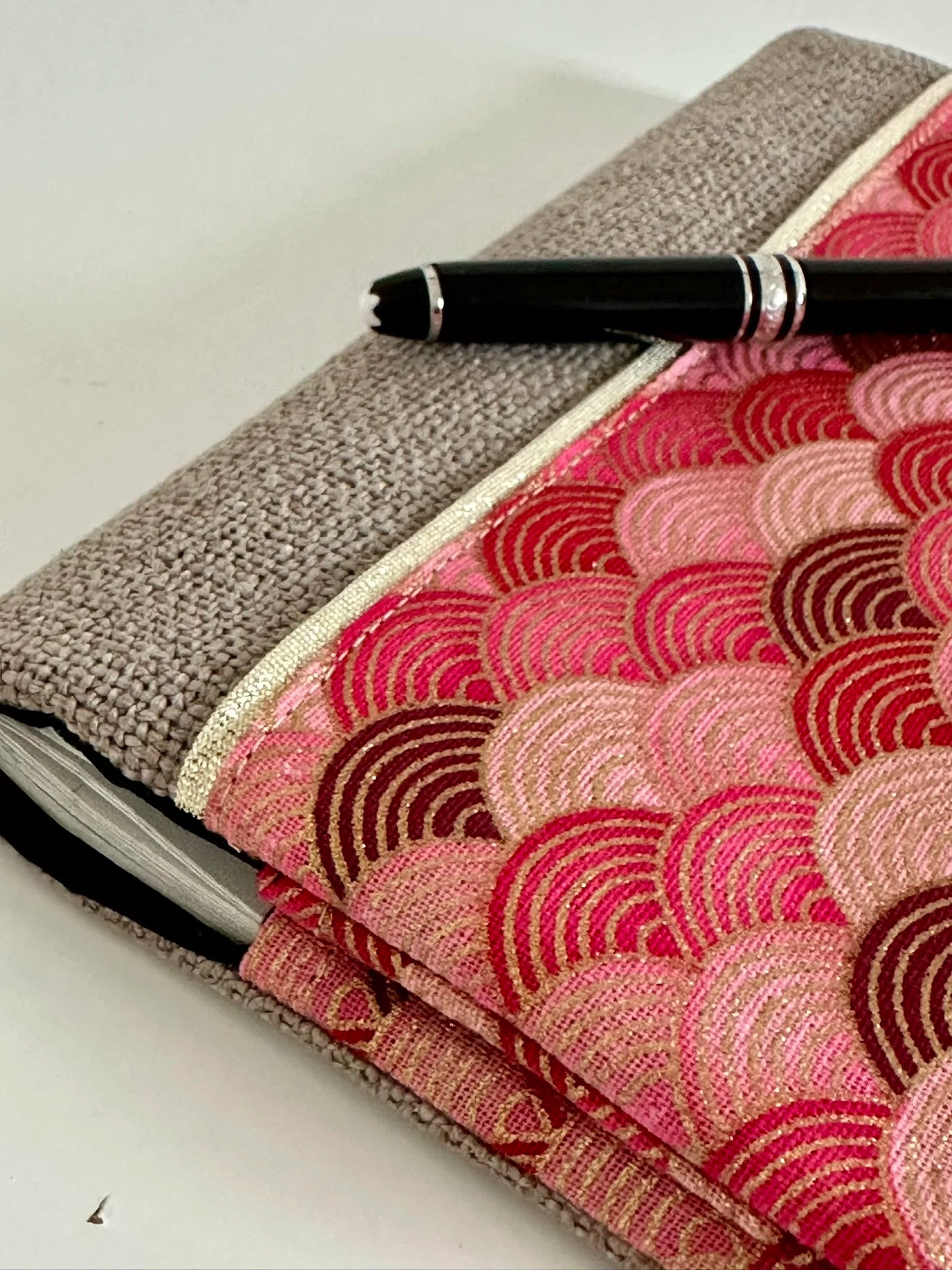 Le liseré doré du porte chéquier en lin et tissu japonais rose et rouge.