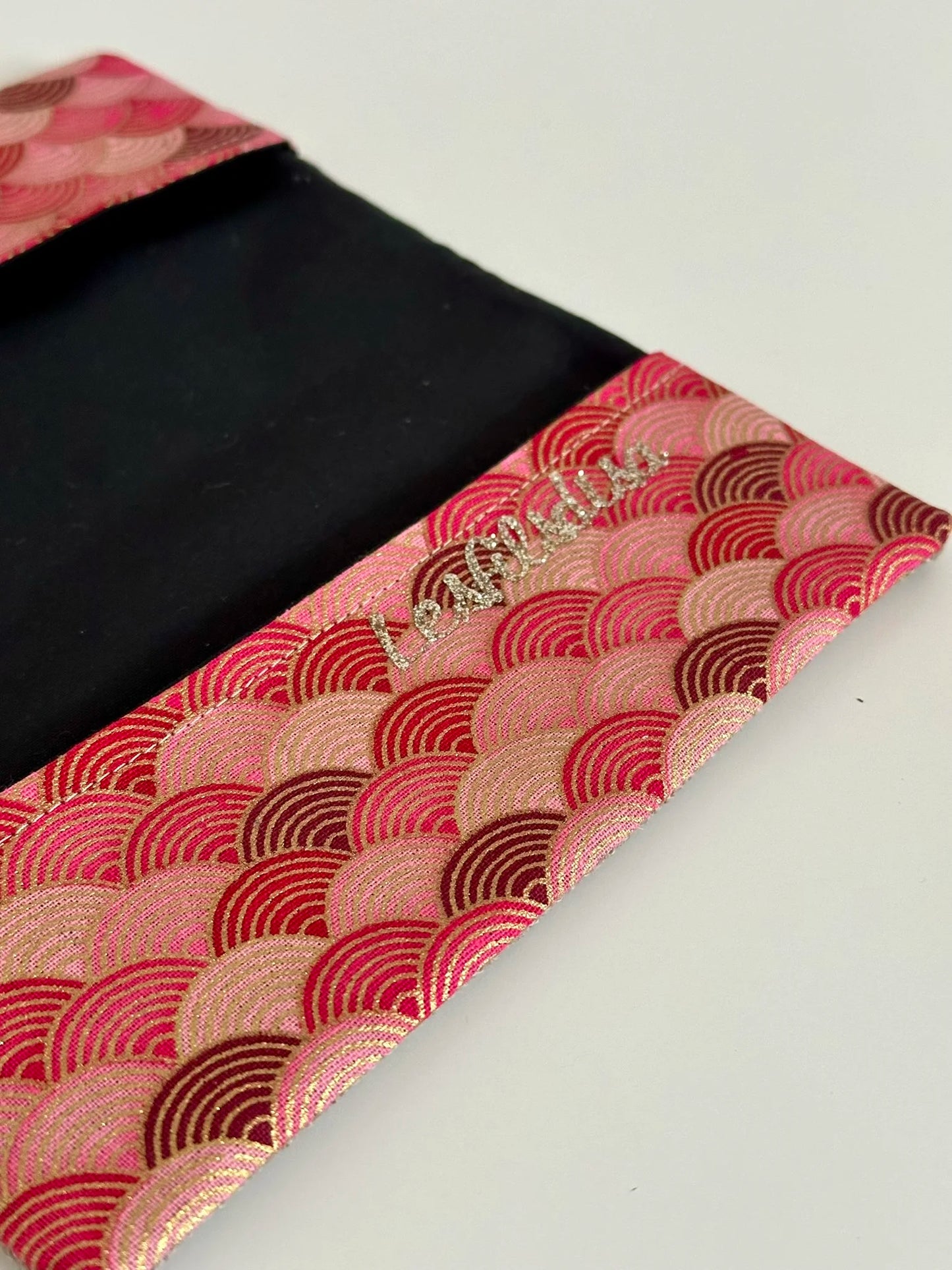 Le rabat inférieur du porte chéquier en lin et tissu japonais rose et rouge.