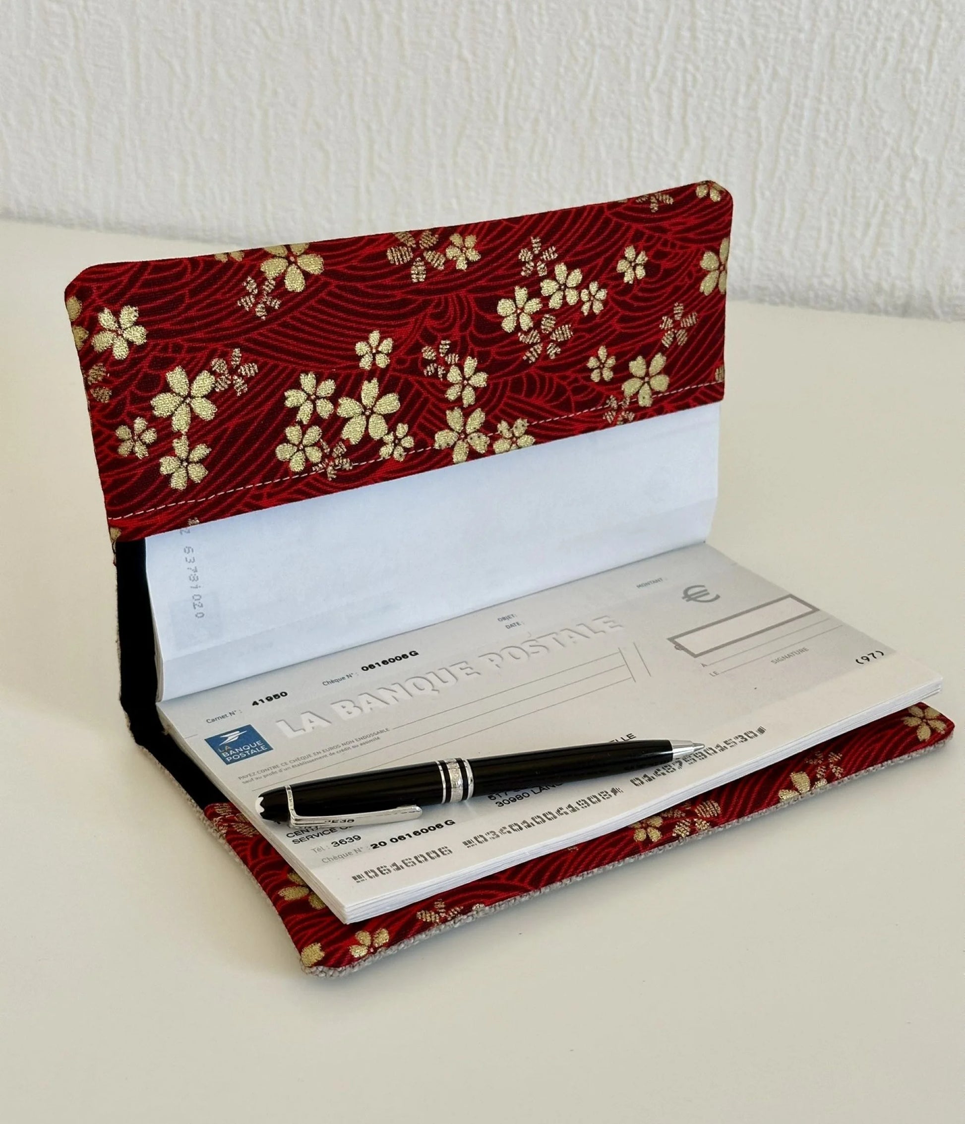 Le porte chéquier en lin et tissu japonais sakura rouge et doré, ouvert avec chéquier à talon haut.