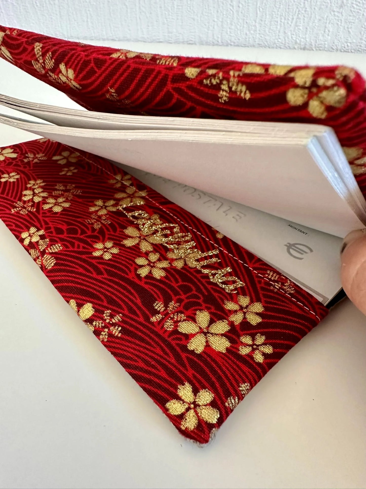 le rabat inférieur du porte chéquier en lin et tissu japonais sakura rouge et doré.