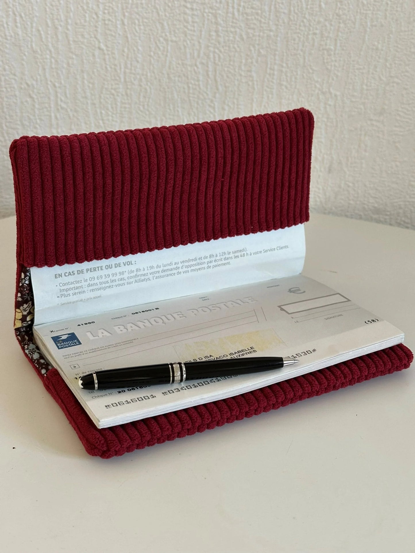 Le porte chéquier en velours bordeaux avec étoile pailletée , ouvert.
