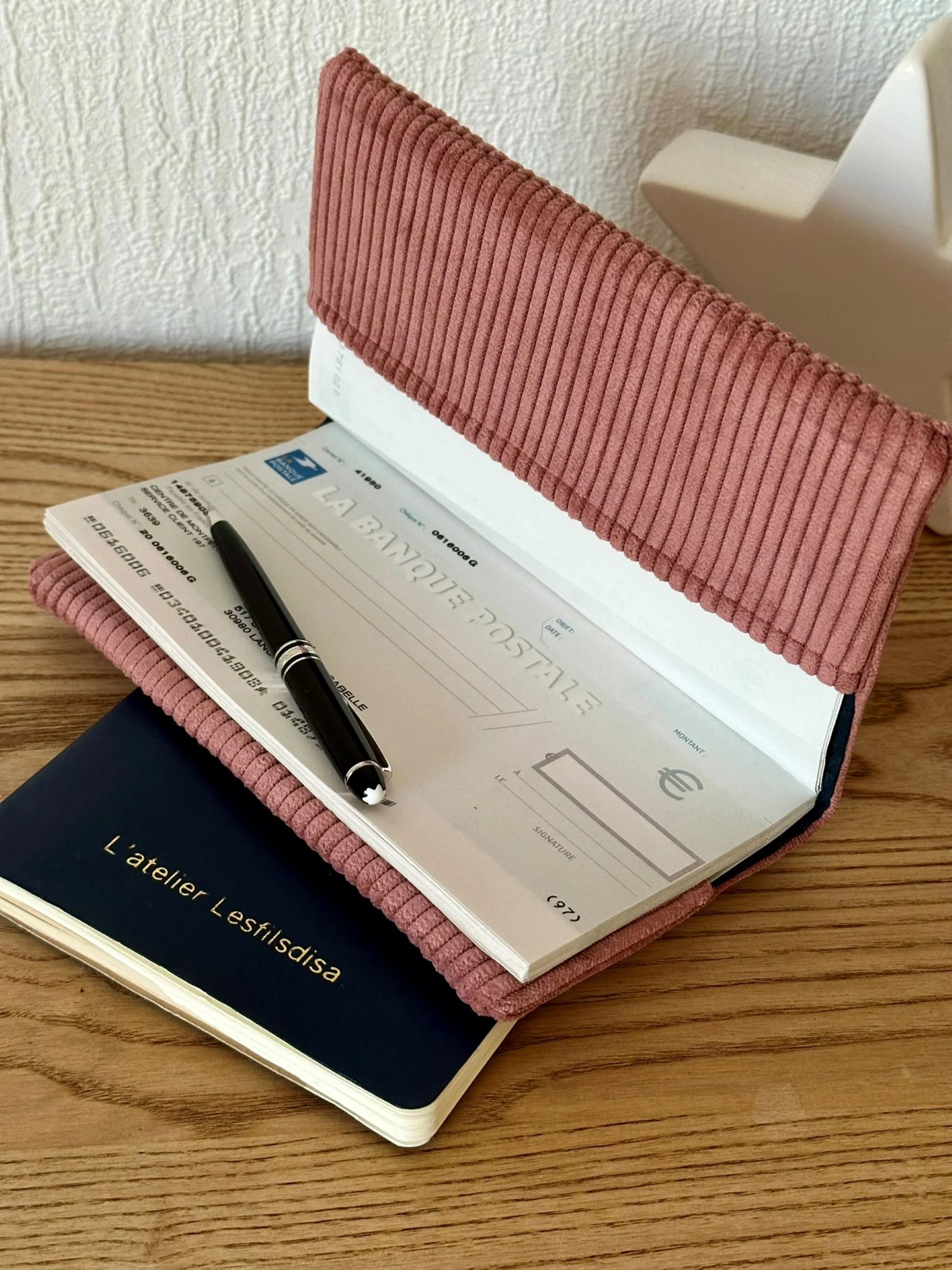 Le porte chéquier en velours cotelé vieux rose et étoile pailletée argentée, ouvert.
