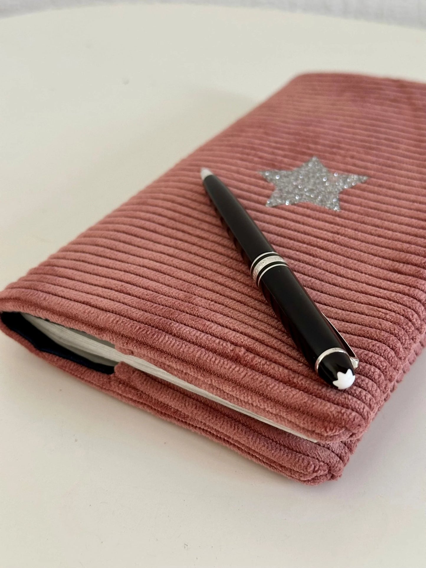 Vue latérale du porte chéquier en velours cotelé vieux rose et étoile pailletée argentée.