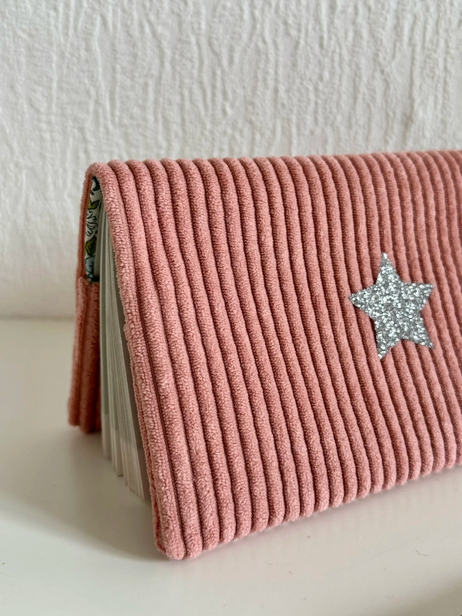 Vue détaillée du porte chéquier en velours rose blush.