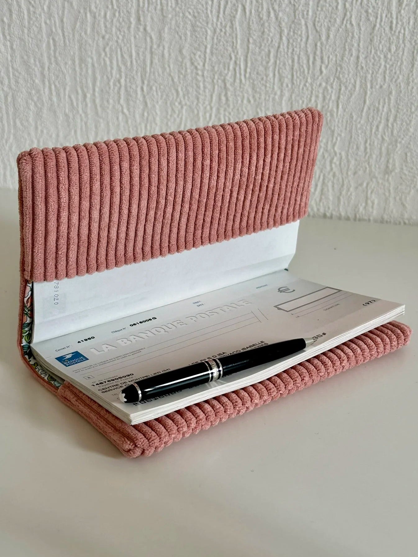 Le porte chéquier en velours rose blush ouvert.