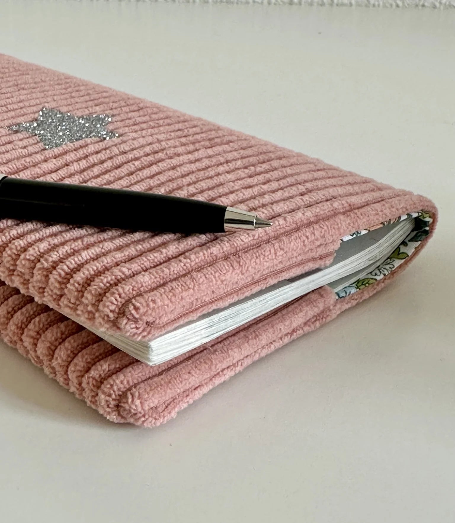 Vue latérale du porte chéquier en velours rose blush.