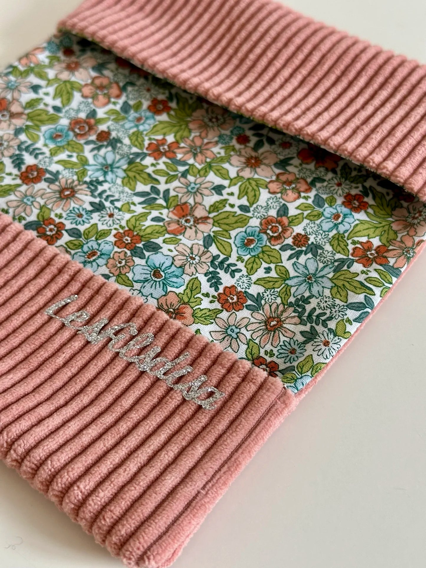 La doublure intérieure fleurie du porte chéquier en velours rose blush.