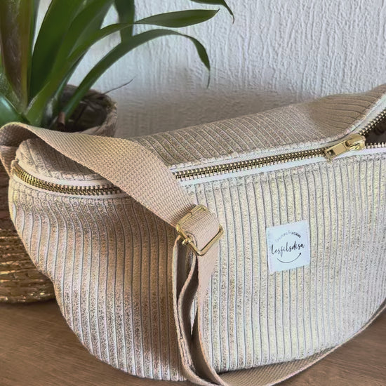 Les reflets dorés du sac banane en velours cotelé doré.