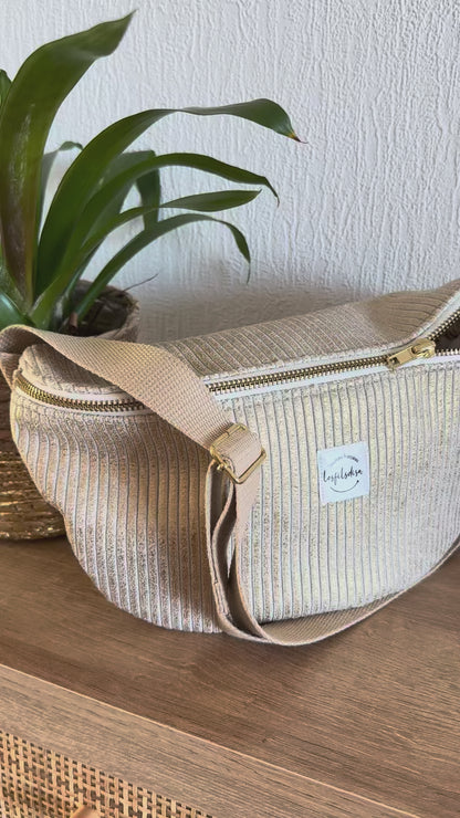 Les reflets dorés du sac banane en velours cotelé doré.