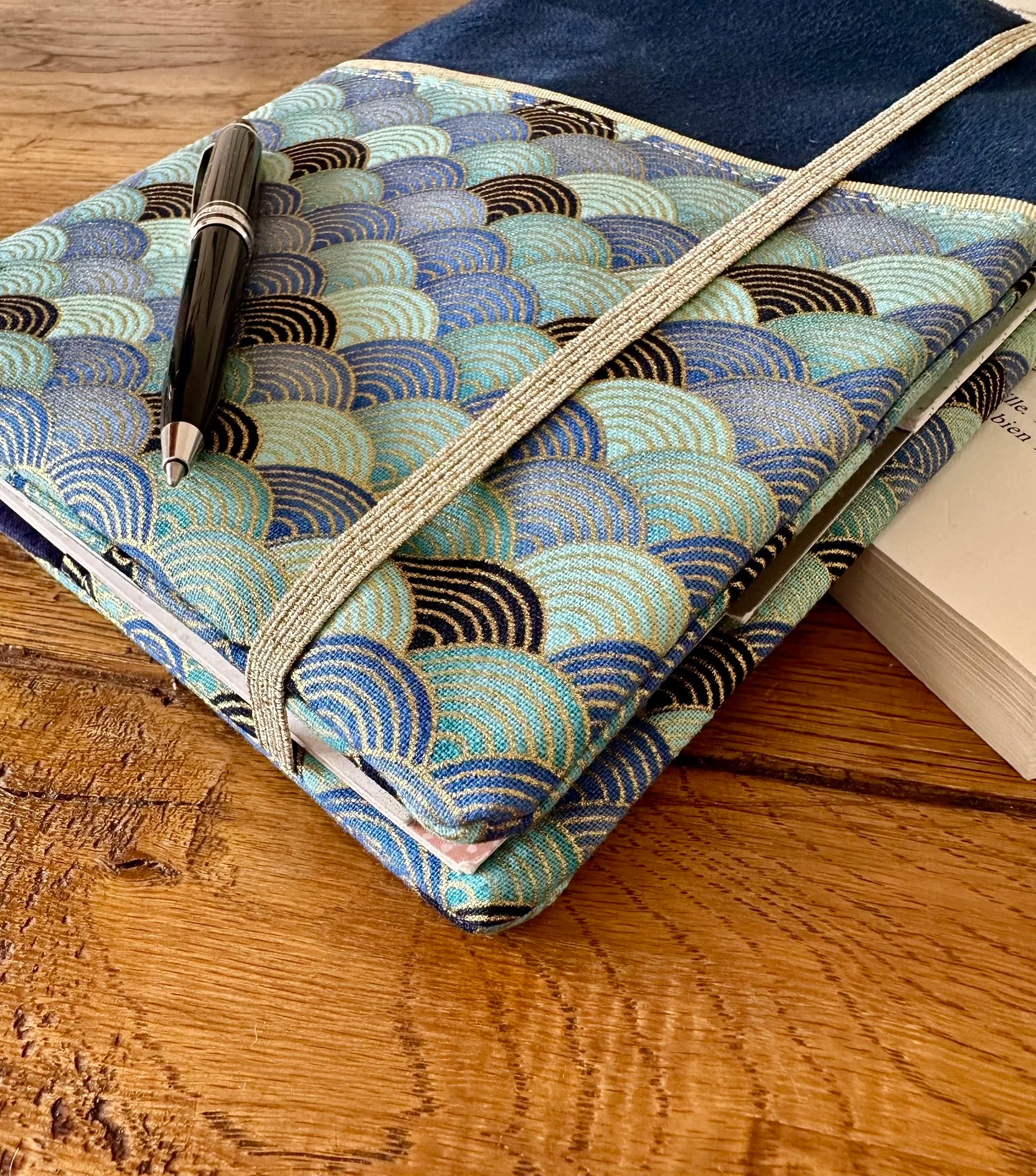 Les petites vagues dorées et turquoise du protège agenda bleu marine en tissu Seigaiha turquoise.