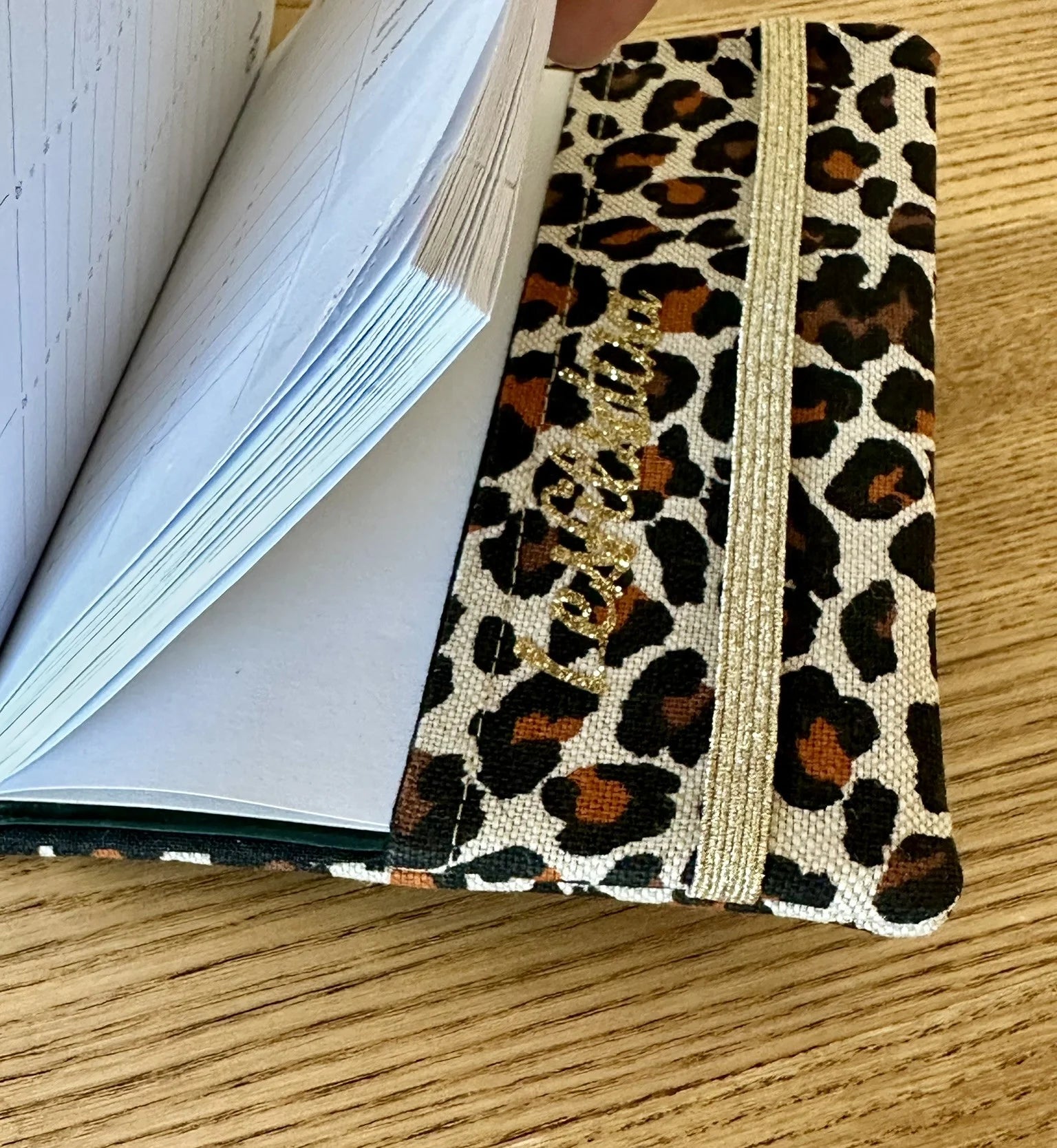 Vue détaillée du protège agenda en lin et tissu léopard.