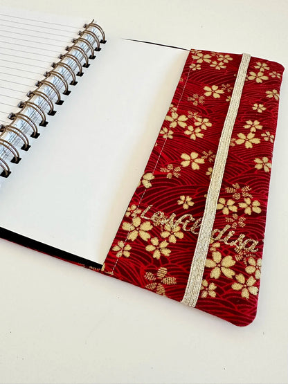 Le rabat inférieur du protège agenda en lin et tissu japonais Sakura rouge.