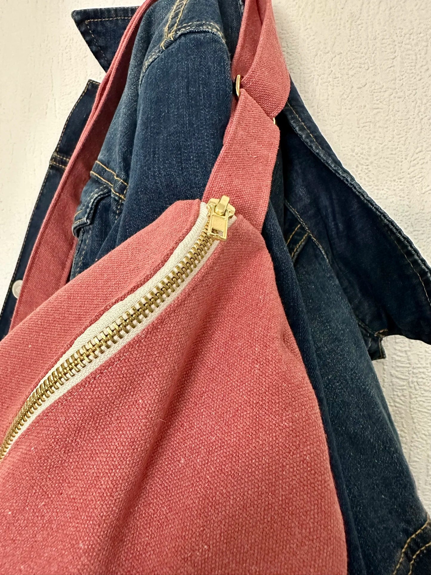La fermeture éclair du sac banane en toile framboise.