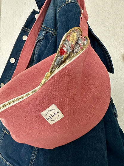 Le sac banane en toile framboise, entrouvert.