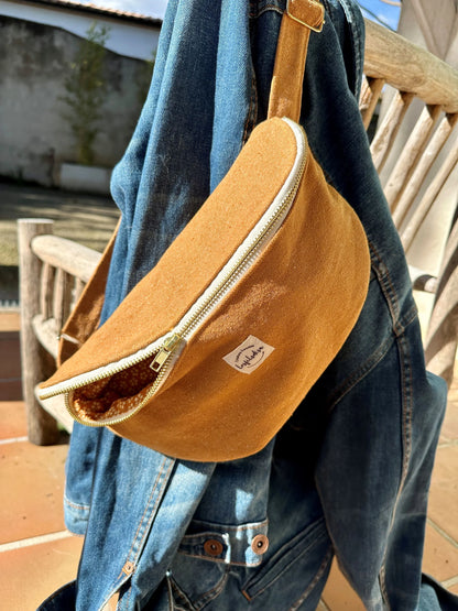 Le sac banane Lesfilsdisa en toile jaune moutarde posé sur veste en jean.