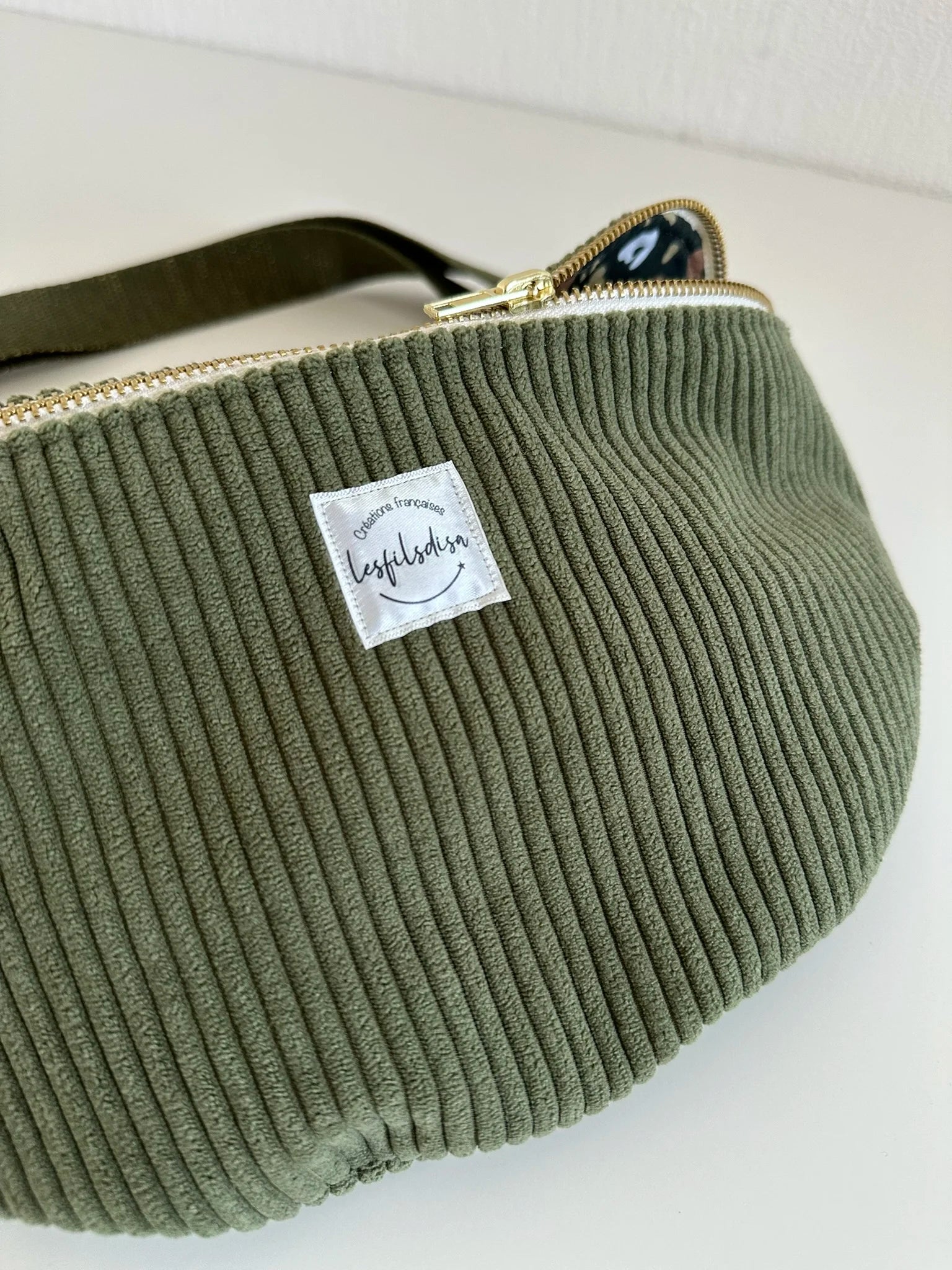 Face avant du sac banane en velours cotelé vert armée.