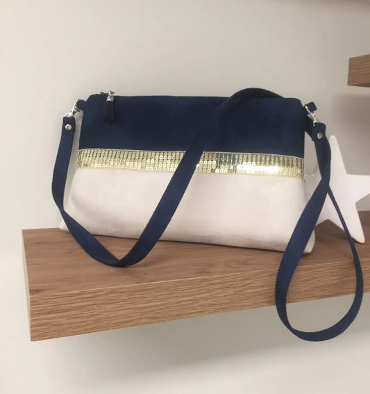 Le sac bandoulière Isa bleu marine et ivoire à paillettes dorées.