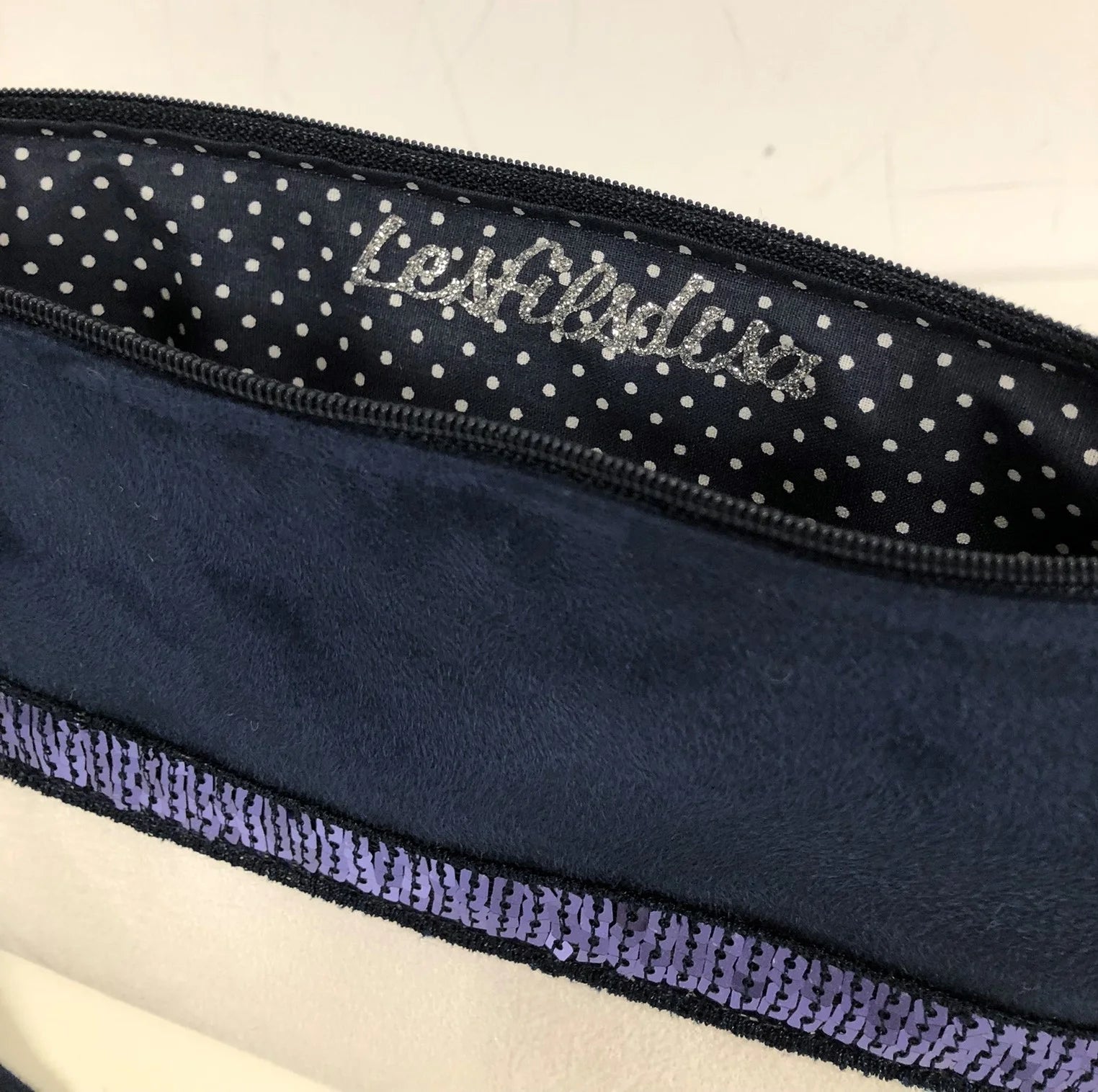 L'intérieur du sac bandoulière Isa bleu marine et blanc à paillettes.