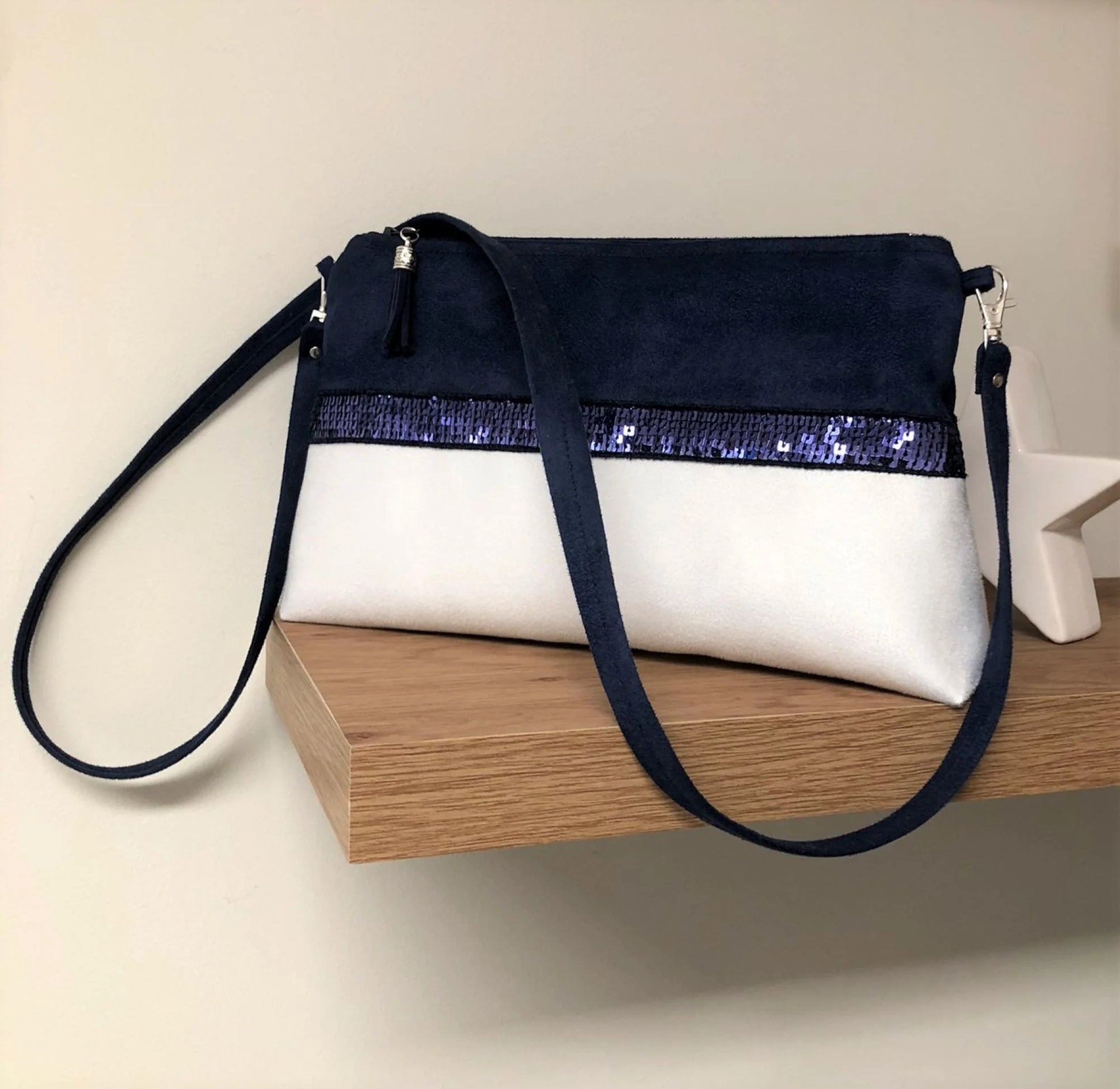 Le sac bandoulière Isa bleu marine et blanc à paillettes.