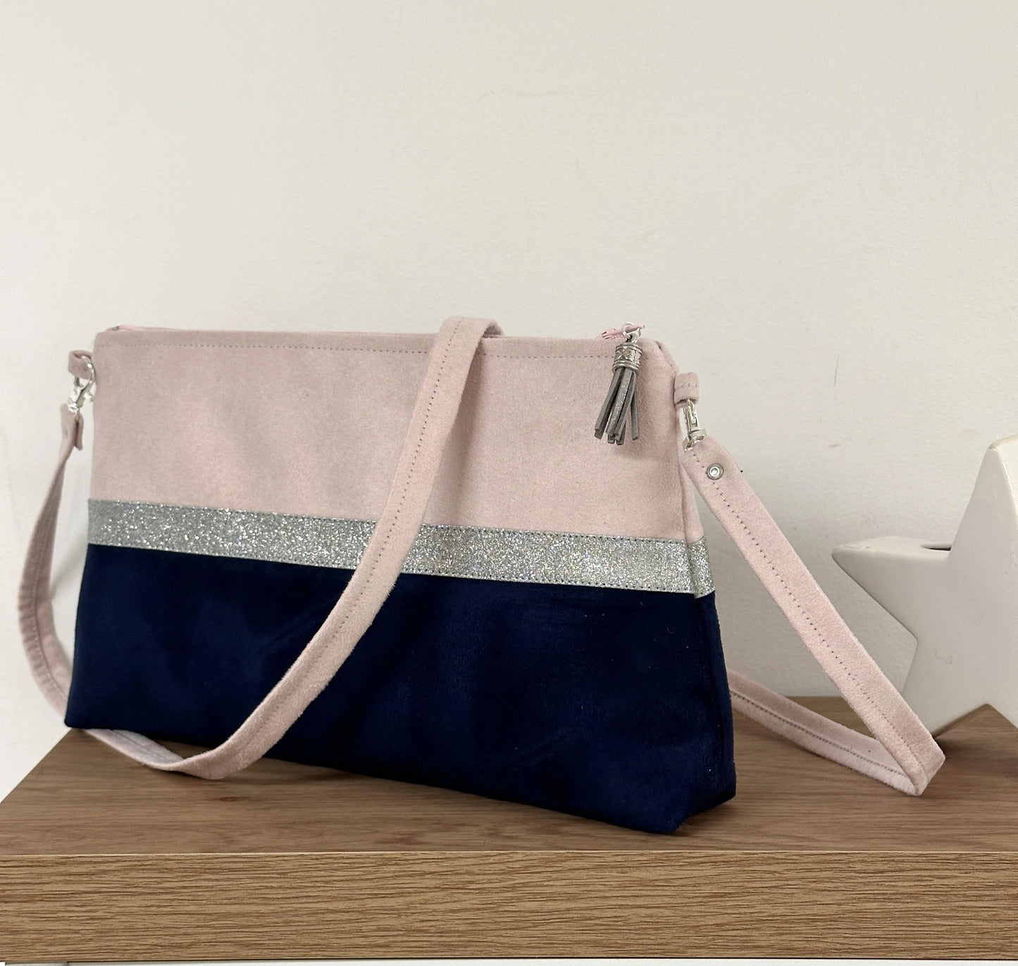 Le sac bandoulière Isa rose pale et bleu marine à paillettes argentées.