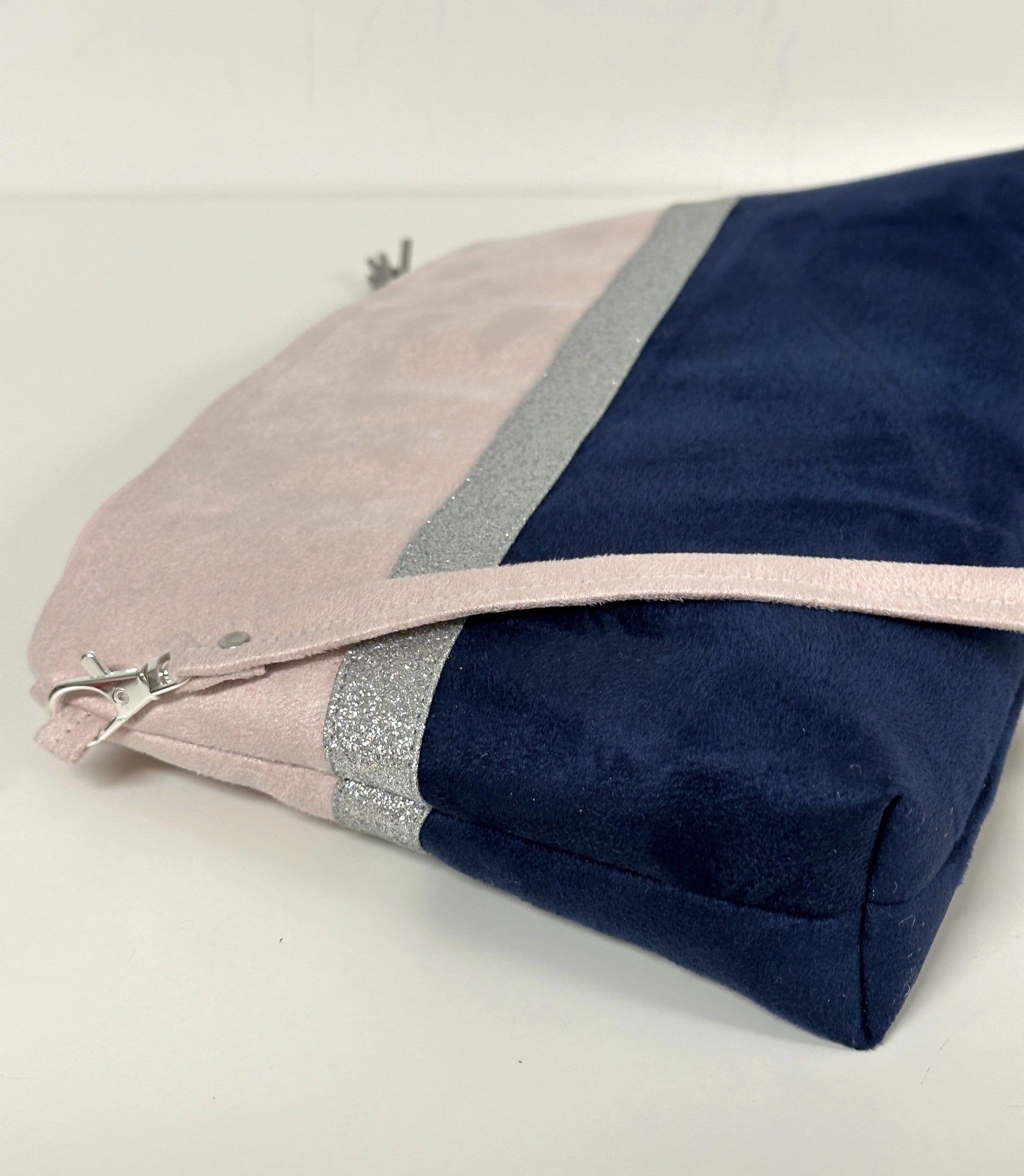 Vue latérale du  sac bandoulière rose pâle et bleu marine à paillettes argentées.