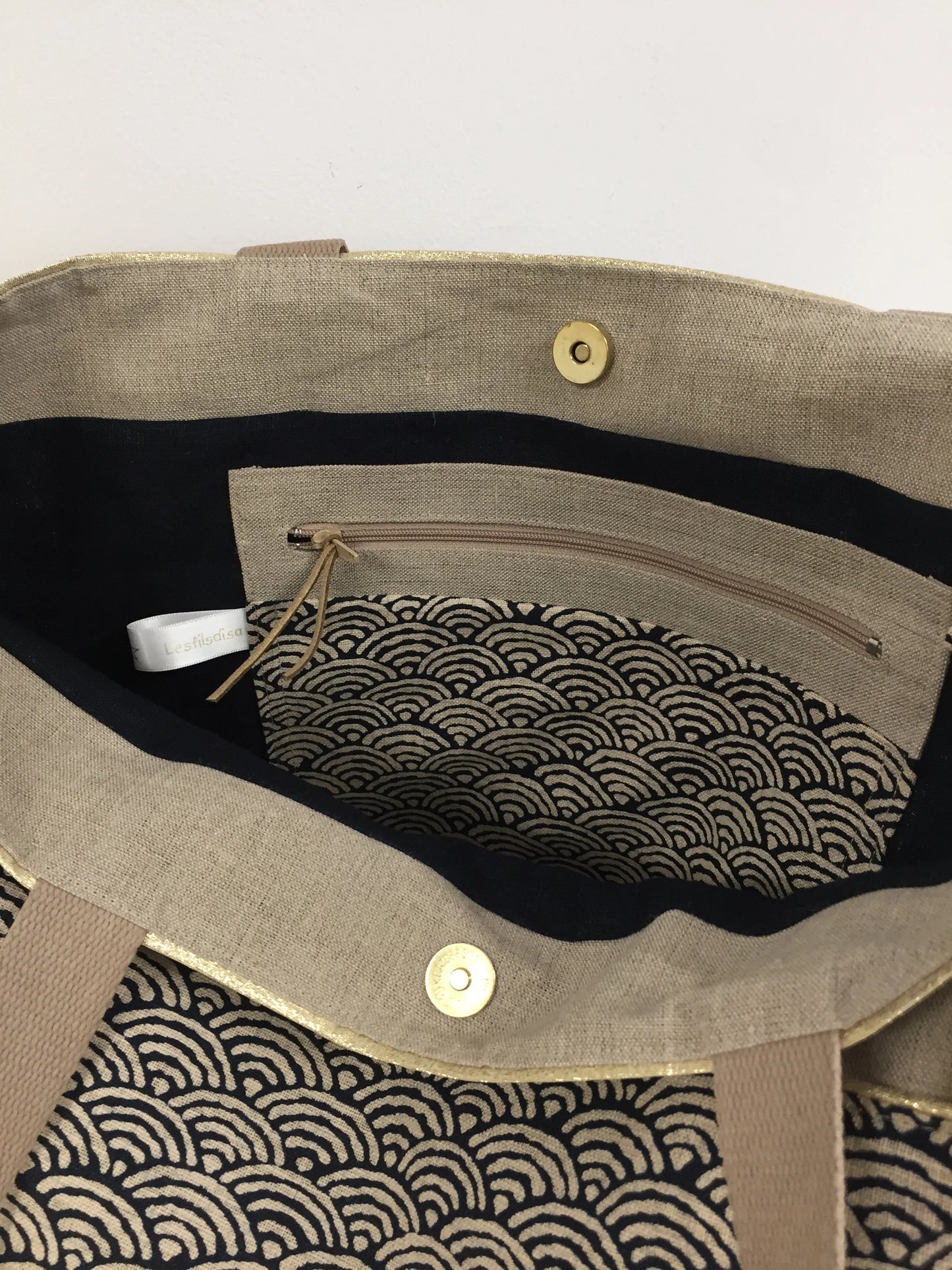 La poche intérieure zippée du sac cabas Isa en lin et tissu japonais bleu nuit, beige et doré.