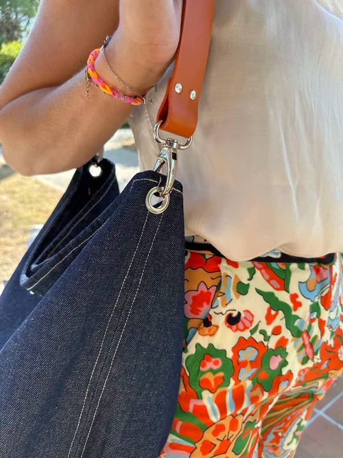 Vue détaillée de l'anse amovible du sac hobo en denim 
