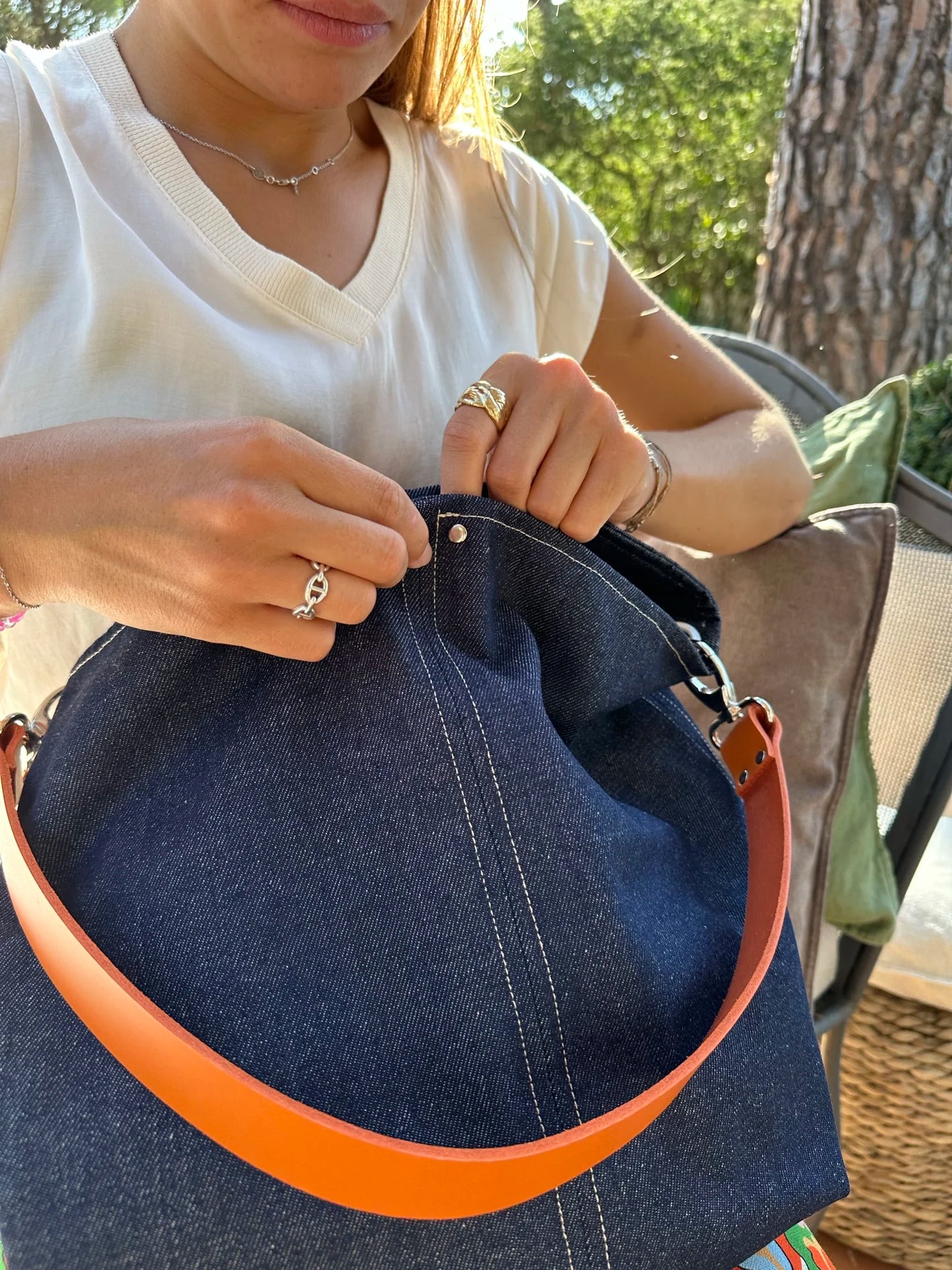 jeune femme qui ferme le sac hobo en denim et cuir orange