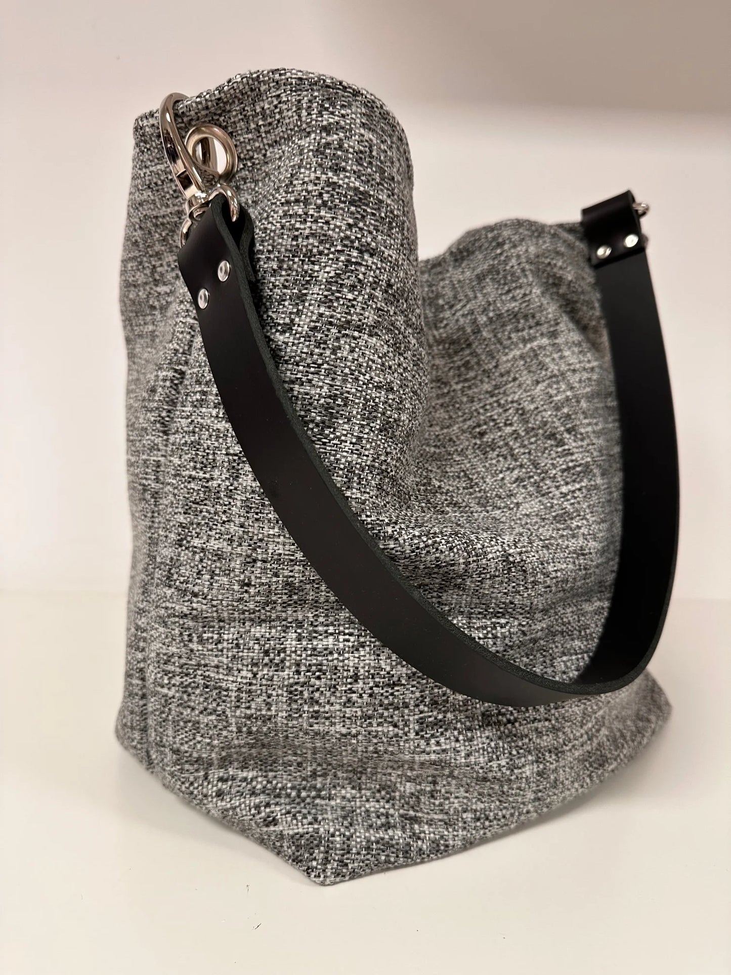 Le sac hobo gris chiné et son anse en cuir  noir.