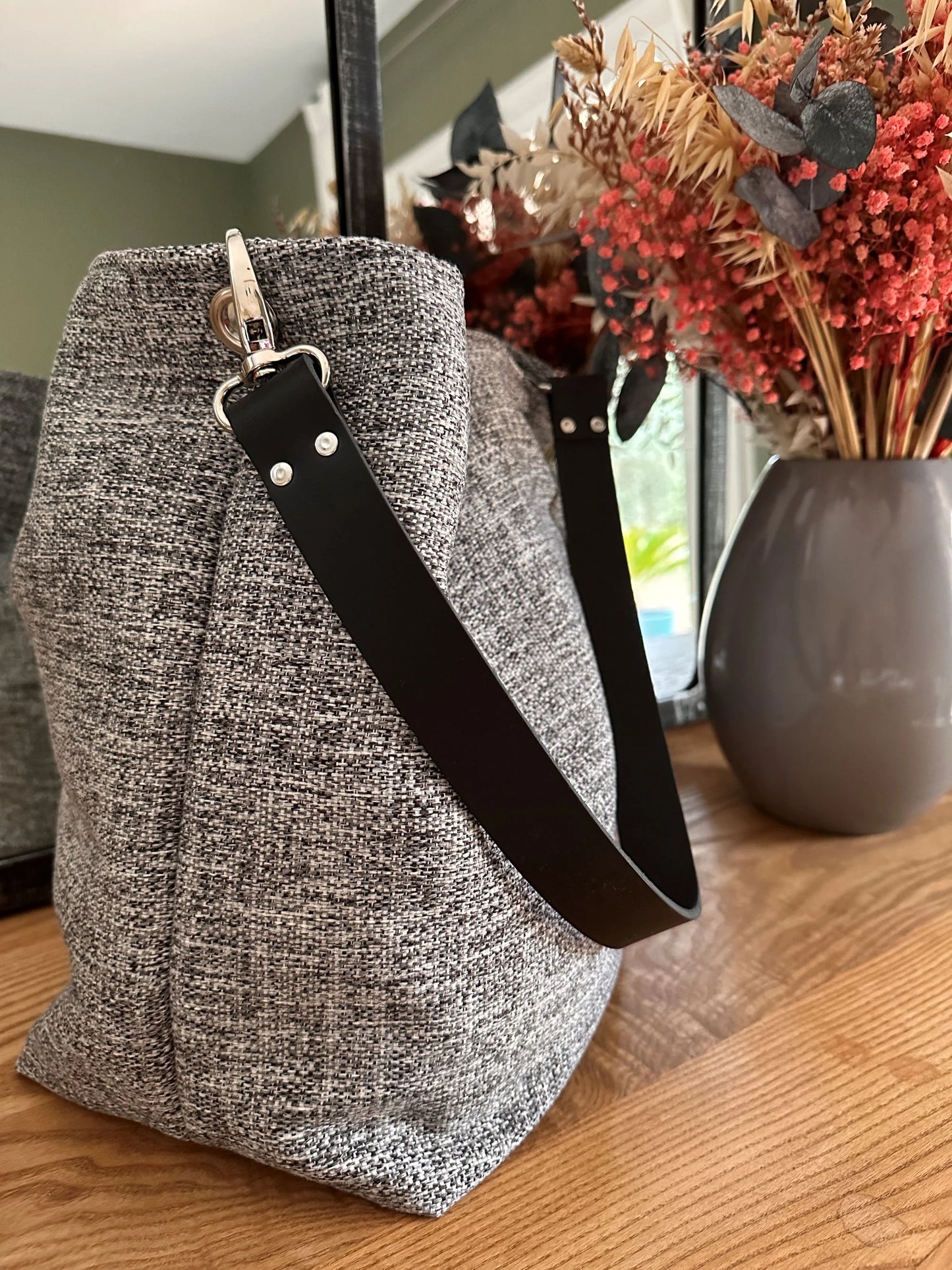 Le sac hobo gris chiné et son anse en cuir noir amovible.