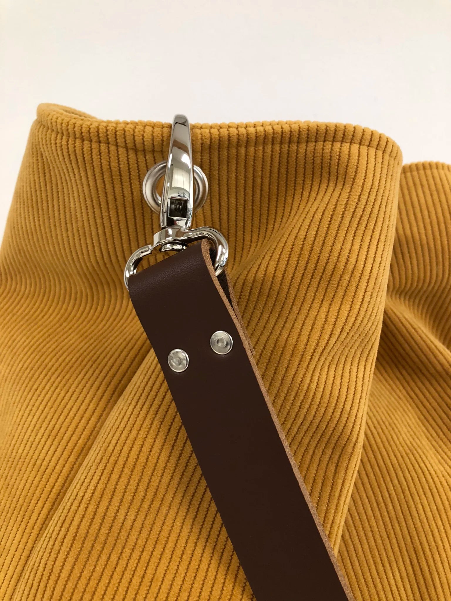 Vue de détail du sac Hobo Lesfilsdisa en velours côtelé jaune moutarde et son anse en cuir marron amovible