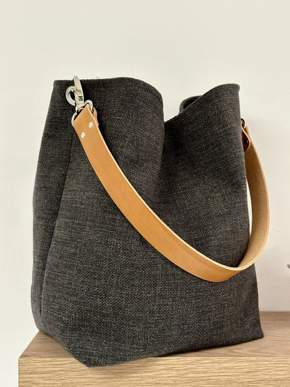 Le sac Hobo en lin anthracite et son anse en cuir fauve, amovible.