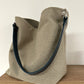 Le sac Hobo en lin beige et son anse en cuir bleu marine amovible