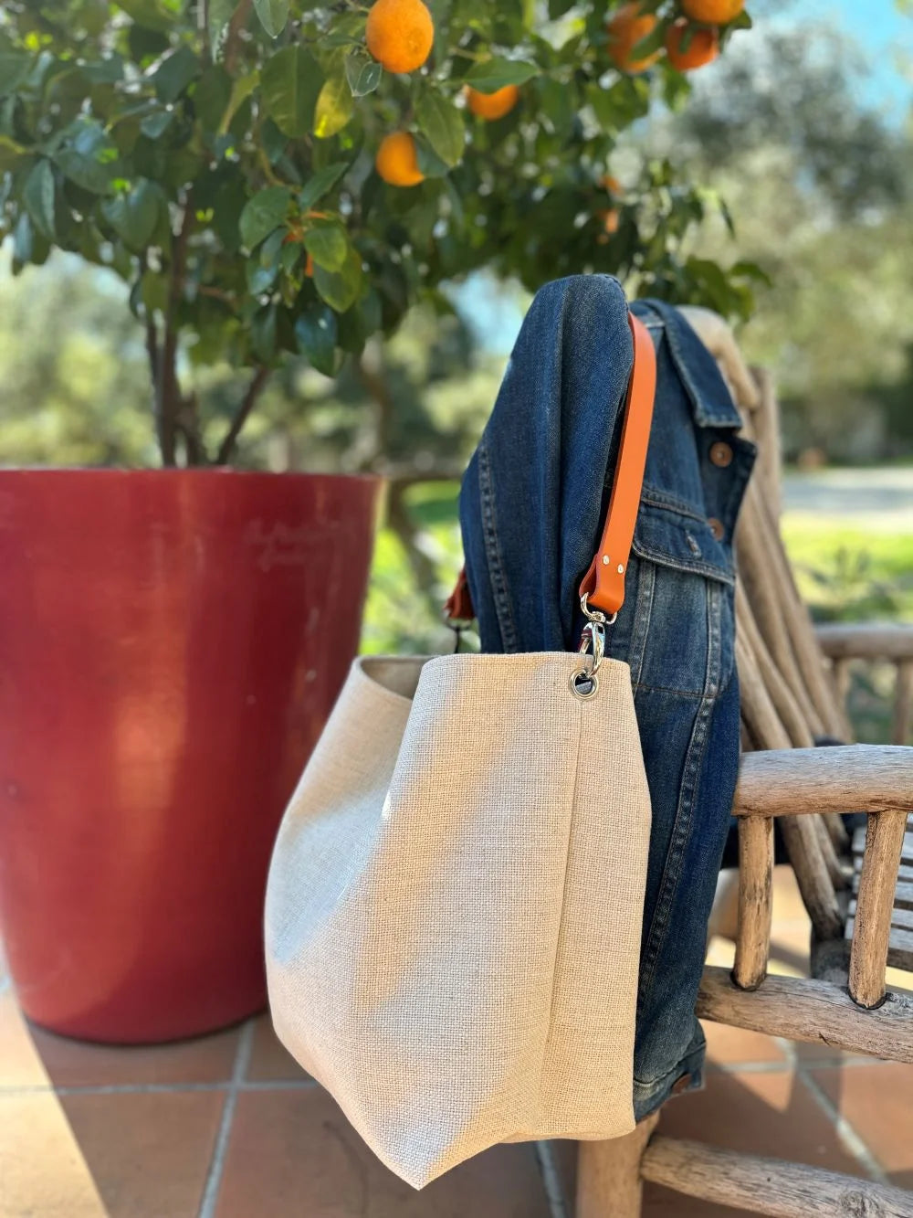 Le sac Hobo en lin ivoire et anse en cuir orange.