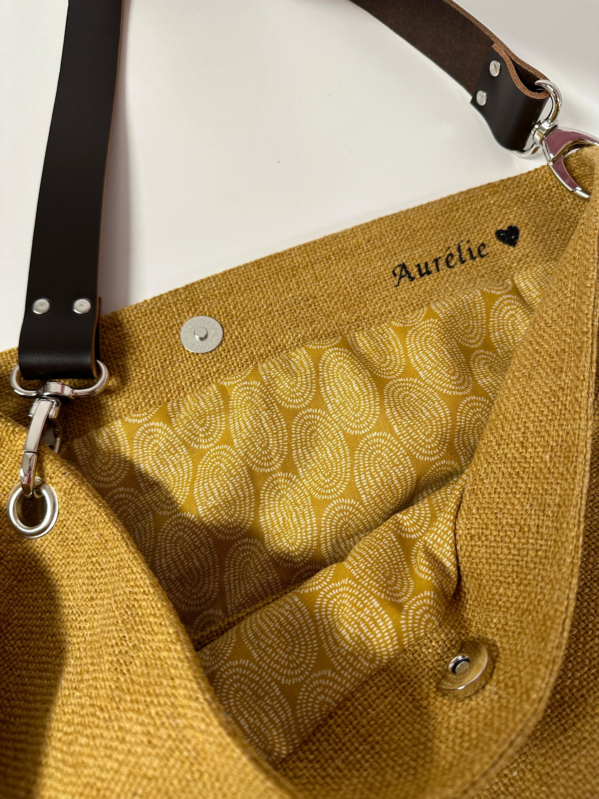 Exemple de personnalisation intérieur du sac hobo en lin jaune moutarde et son anse en cuir marron amovible.