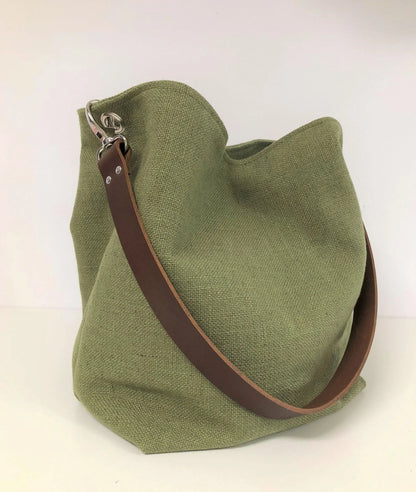 Le sac hobo en lin vert kaki et son anse en cuir marron amovible.