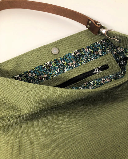 La poche intérieure zippée du sac hobo en lin vert kaki et son anse en cuir marron amovible.