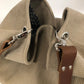 Vue de détail de l'anse en cuir marron accrochée au sac hobo Lesfilsdisa en velours côtelé beige