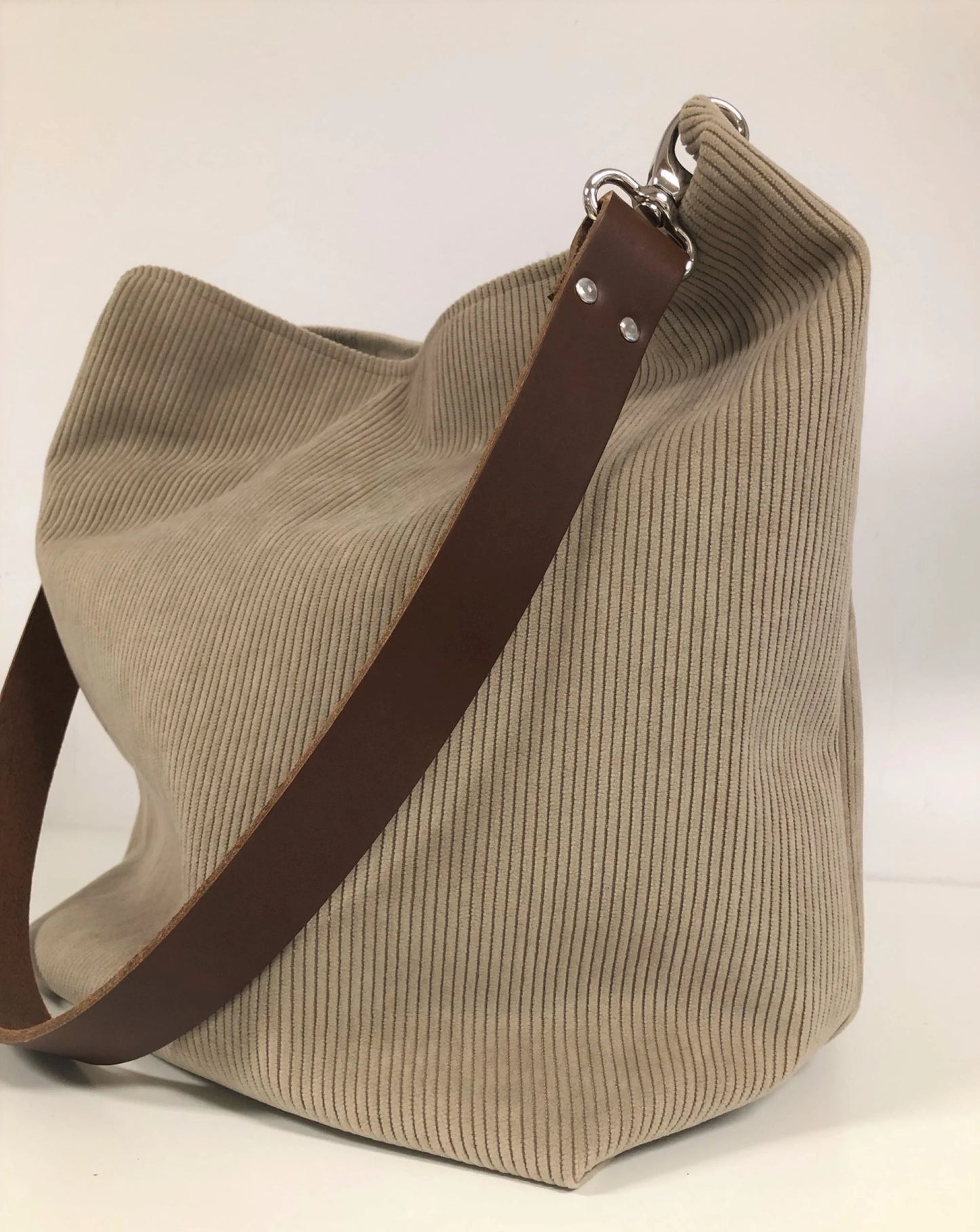 Le sac hobo en velours cotelé beige et son anse amovible en cuir marron