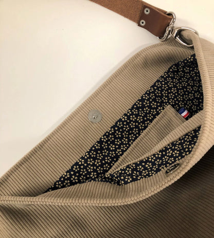 La deuxième poche intérieure du sac hobo en velours cotelé beige et son anse en cuir marron.