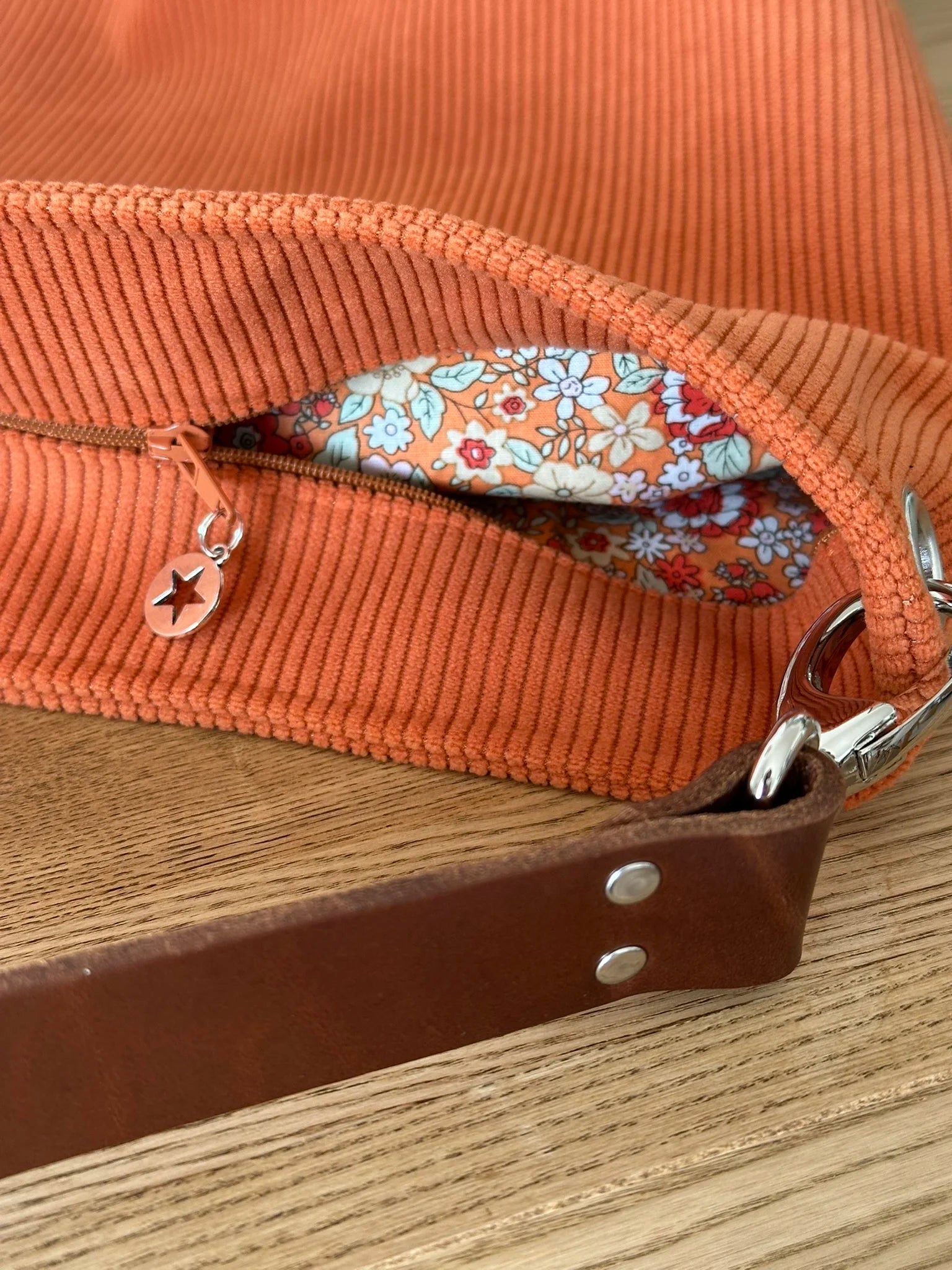 Le sac Hobo en velours orange fermé par une fermeture éclair.