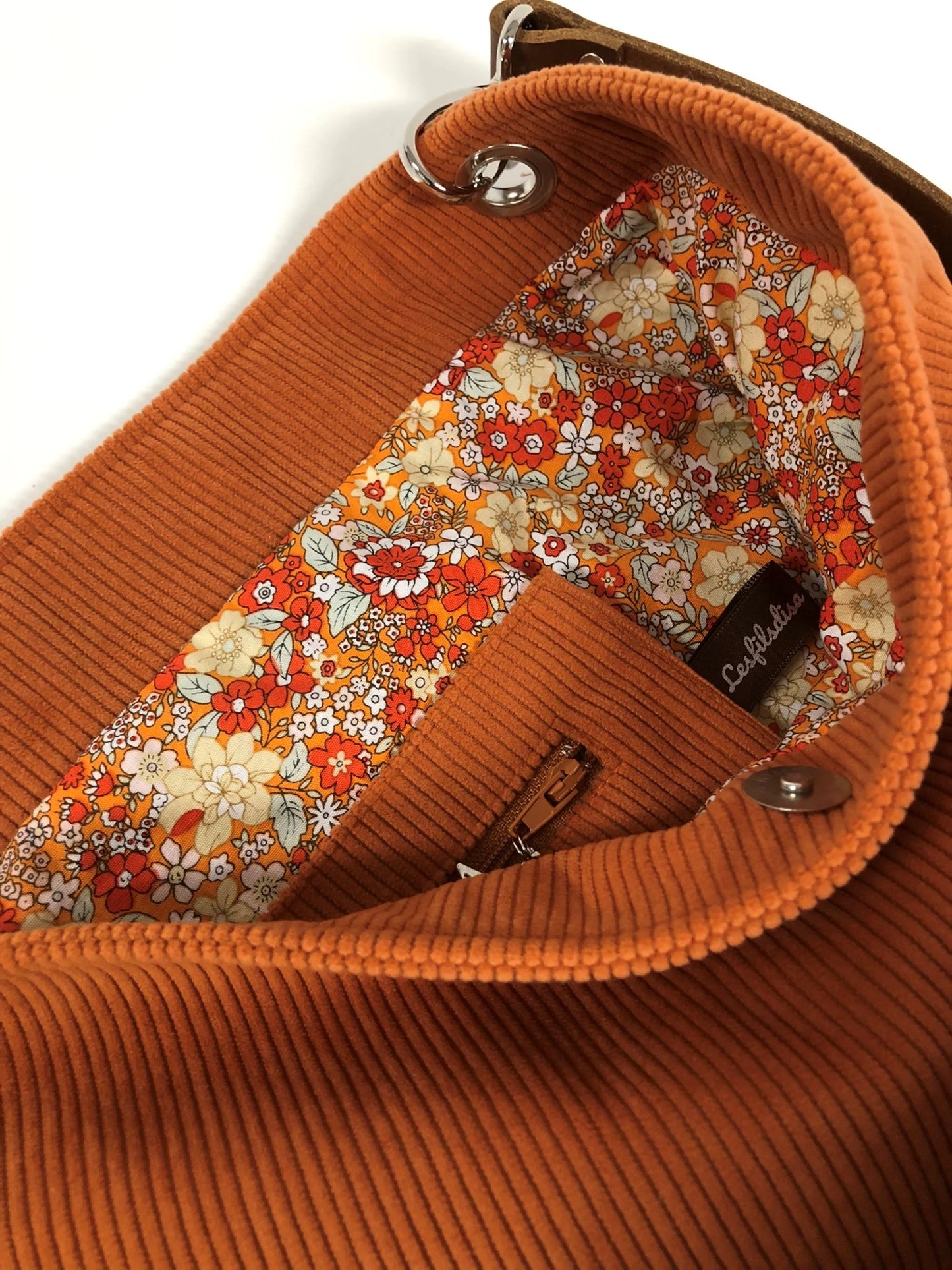 La poche intérieure zippée du sac hobo Lesfilsdisa en velours côtelé orange et son anse en cuir marron amovible