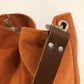 Vue détaillée de l'anse en cuir marron du sac hobo Lesfilsdisa en velours côtelé orange 