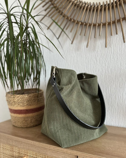 Vue d'ensemble du sac Hobo en velours cotelé vert armée et son anse en cuir noir amovible.
