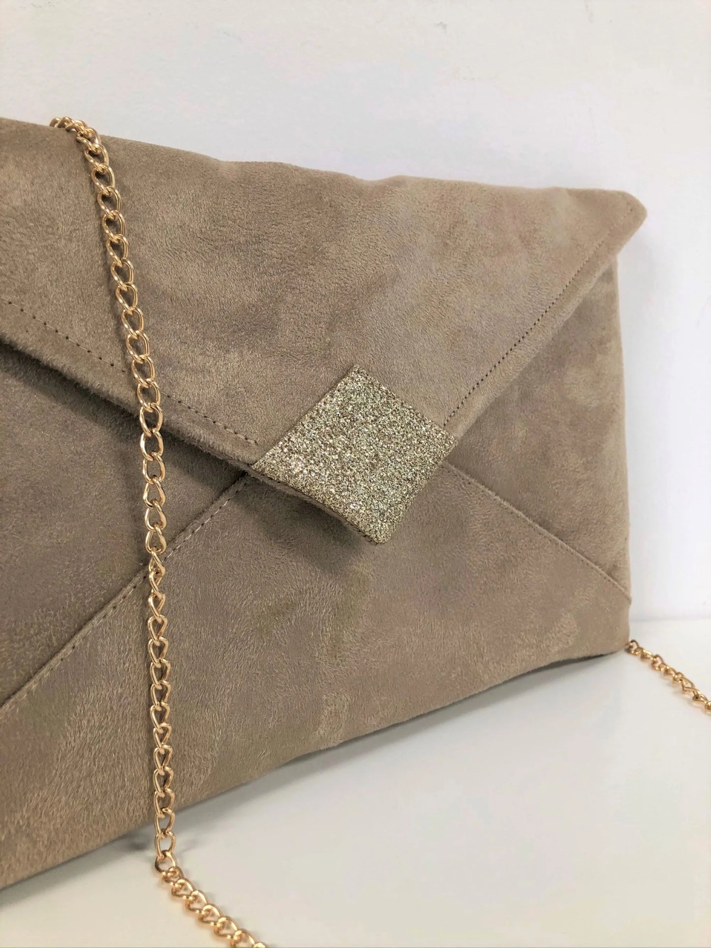 Vue détaillée du rabat du sac pochette Isa beige à paillettes dorées.