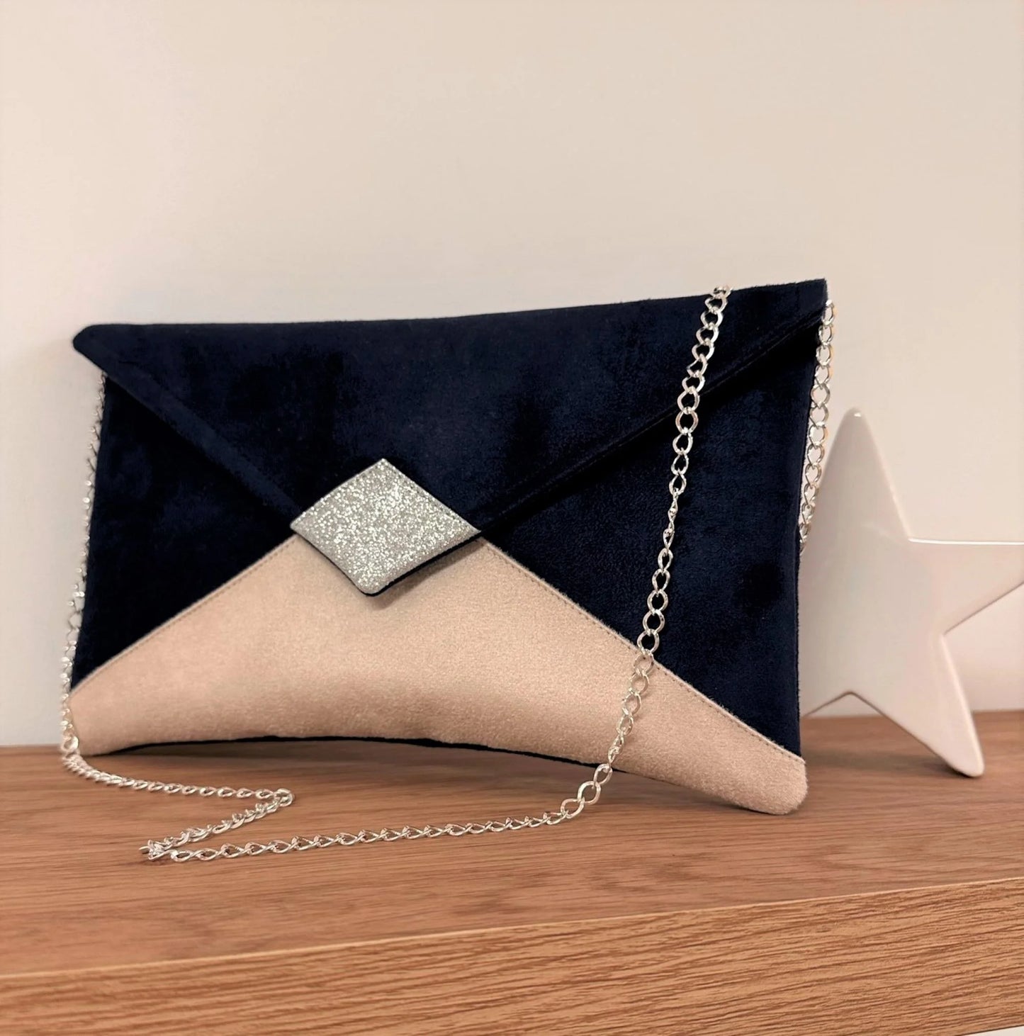 Le sac pochette Isa bleu marine et beige nude à paillettes argentées avec sa chainette amovible.