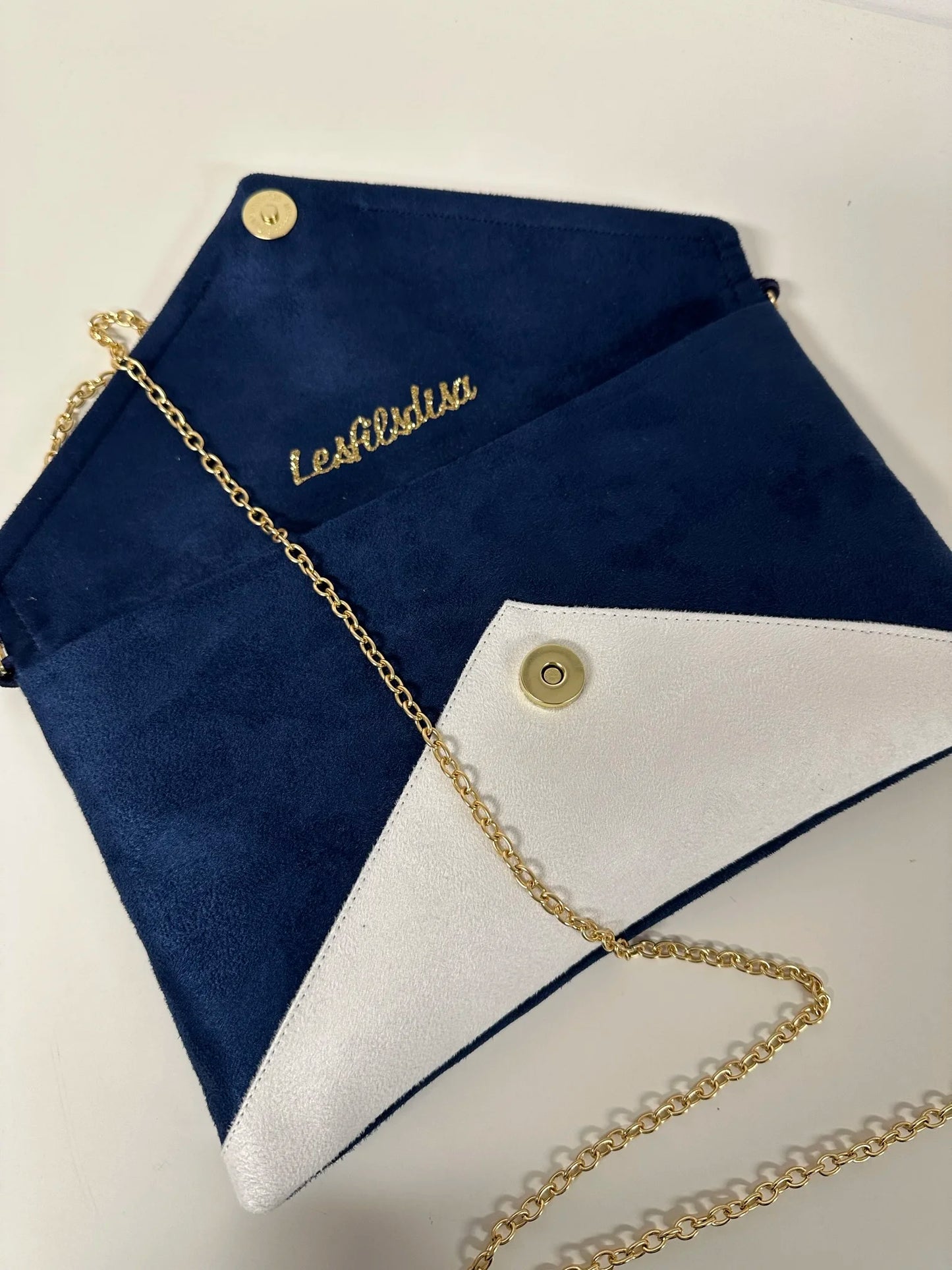 Le sac pochette Isa bleu marine et blanc à paillettes dorées, ouvert.