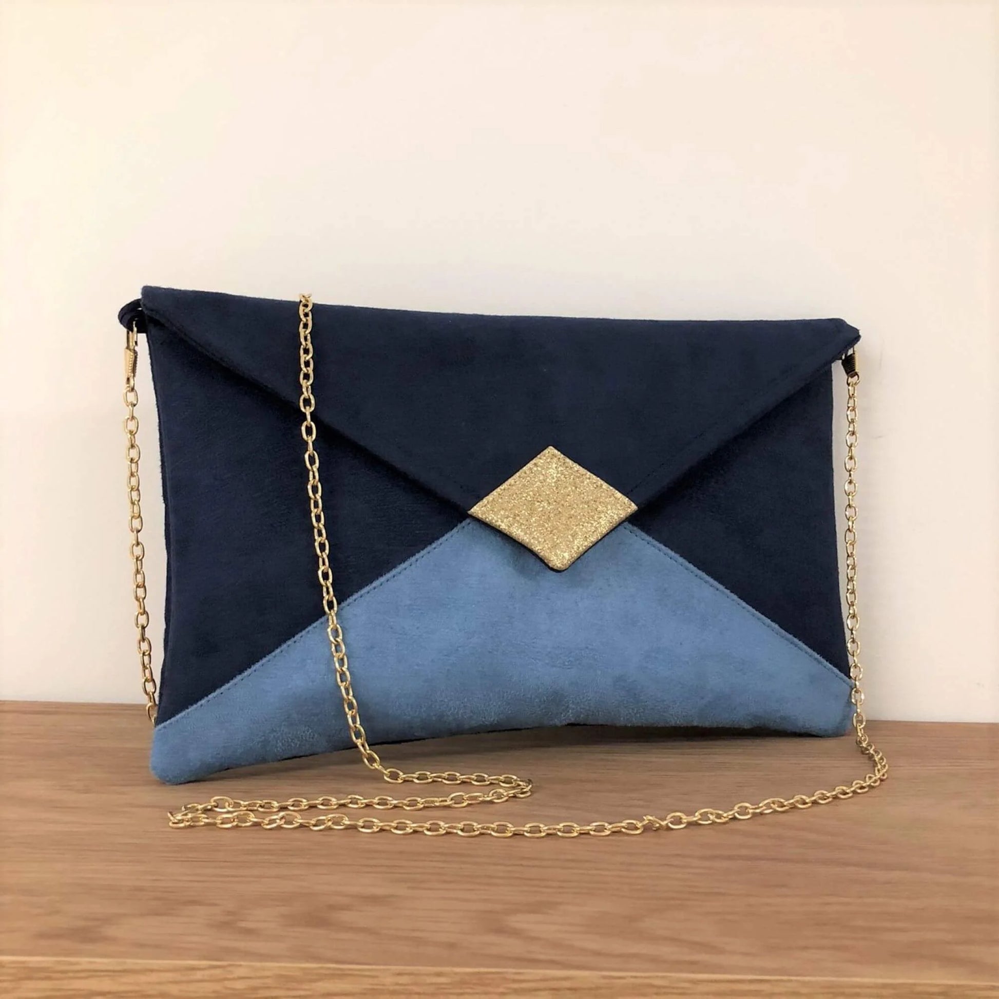 Le sac pochette Isa bleu marine et bleu ciel à paillettes dorées, avec chainette amovible.
