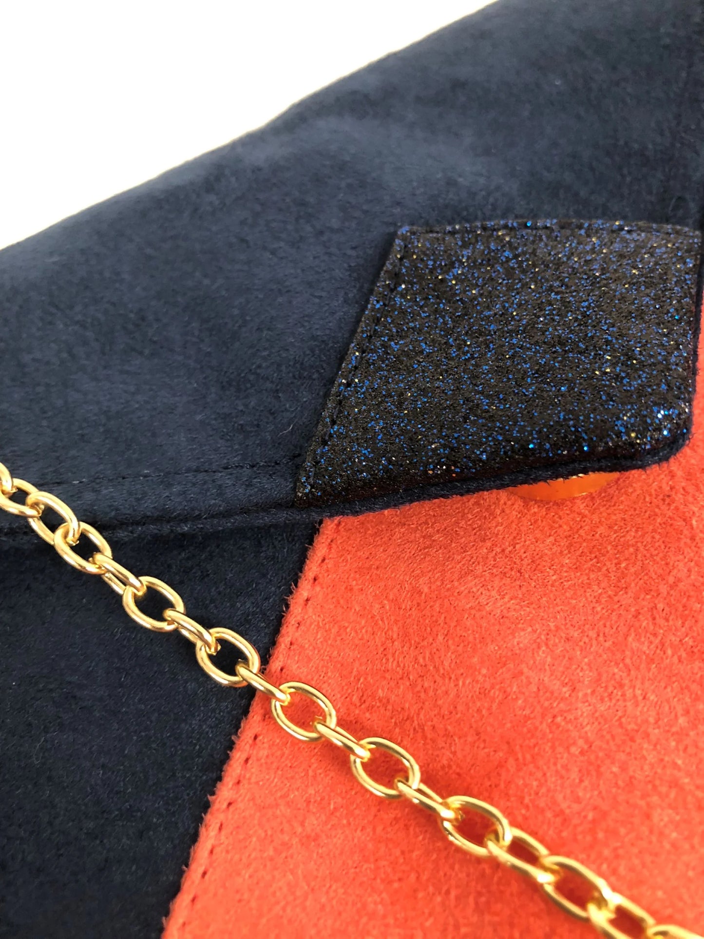 Vue détaillée du sac pochette Isa bleu marine et corail à paillettes bleu marine.